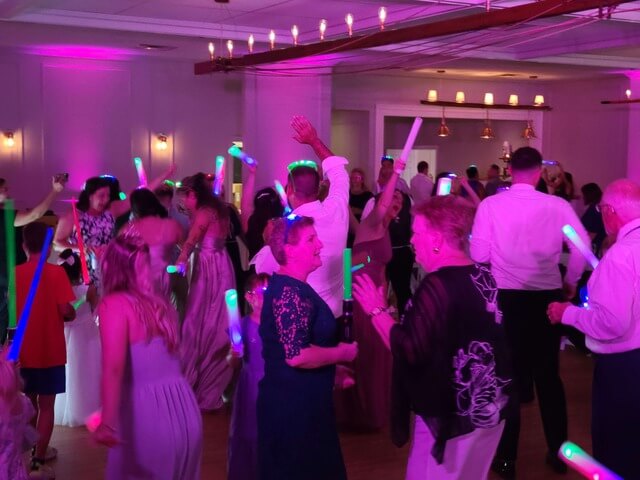A full dance floor under violet uplighting